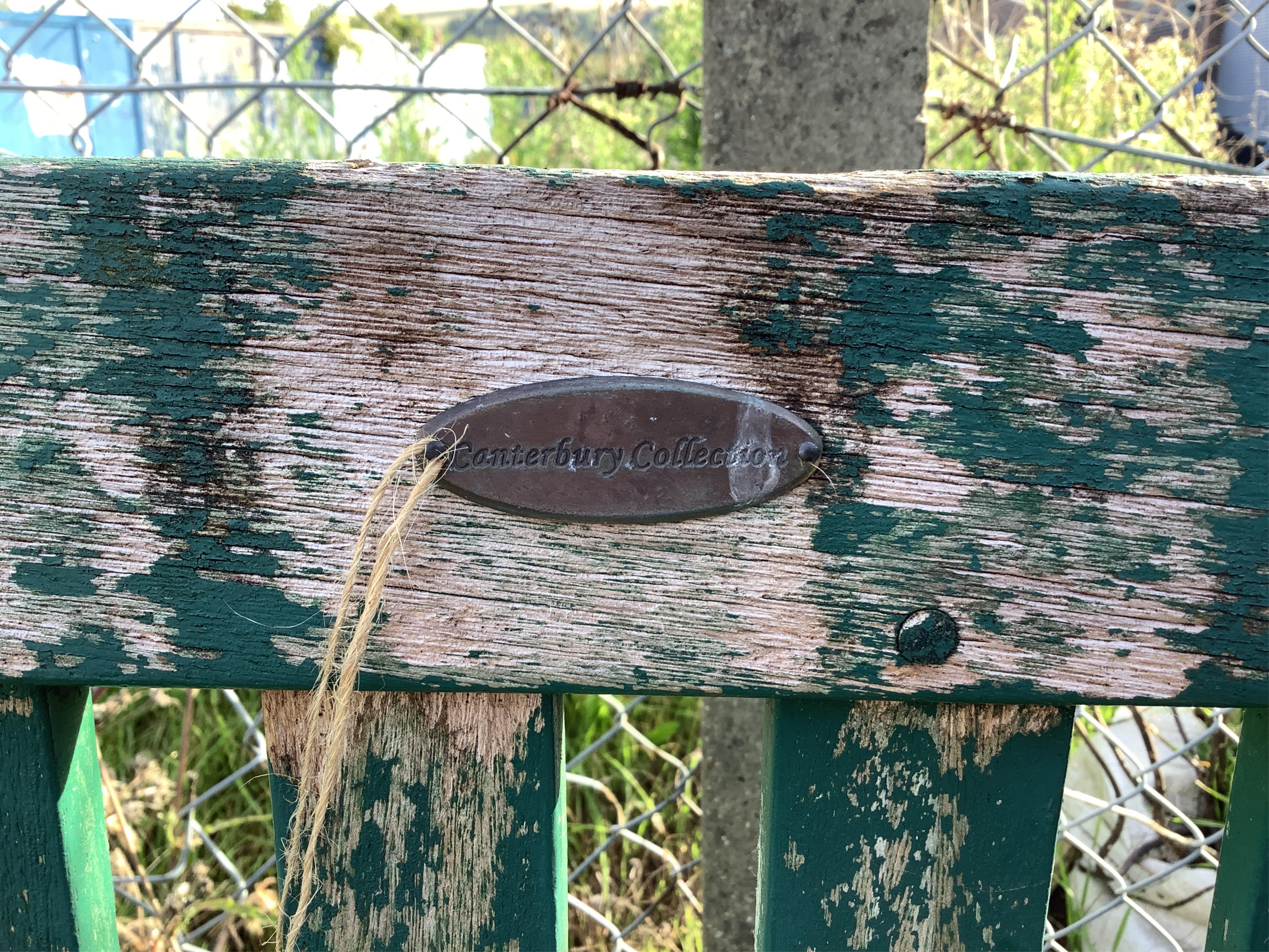 A green painted teak garden bench, width 138cm. Condition - weathered, otherwise fair